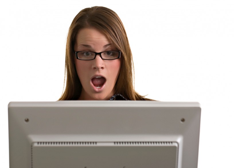 Woman looks shocked at a computer screen