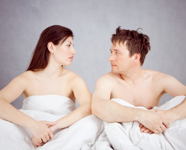 Man and woman look at each other in bed
