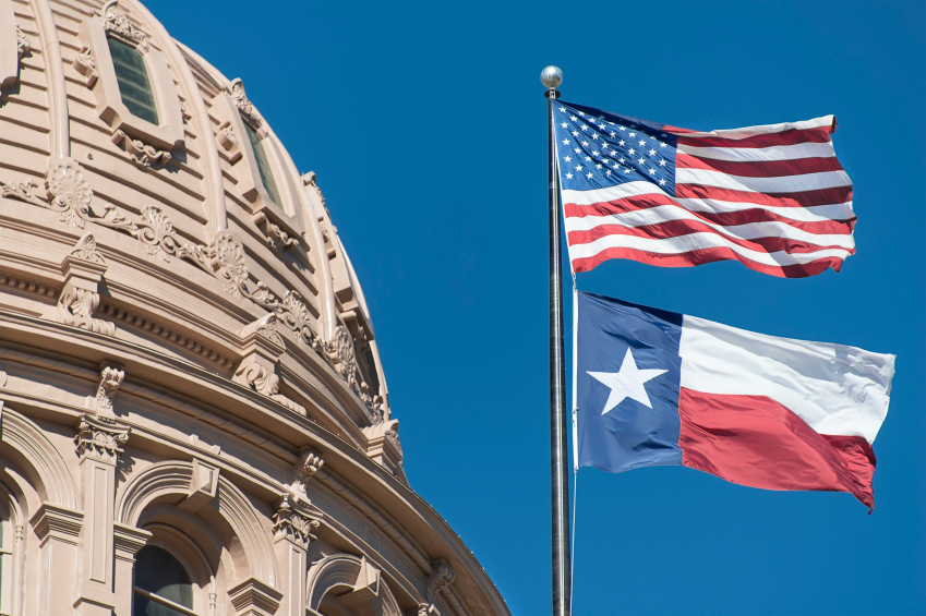 The capitol building in Texas with the US and Texas flag flying