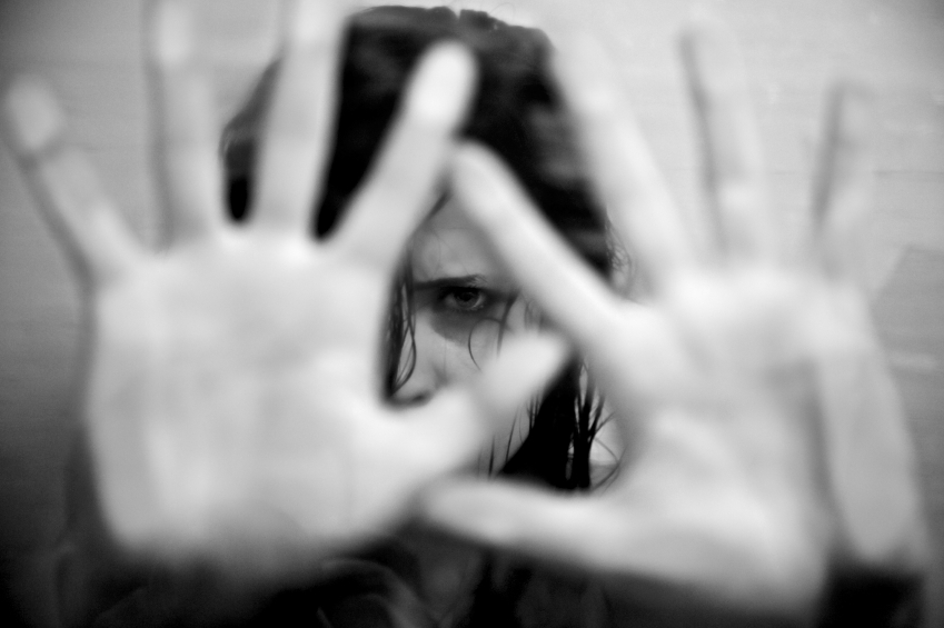 Black and white picture of a woman putting her hands over her face