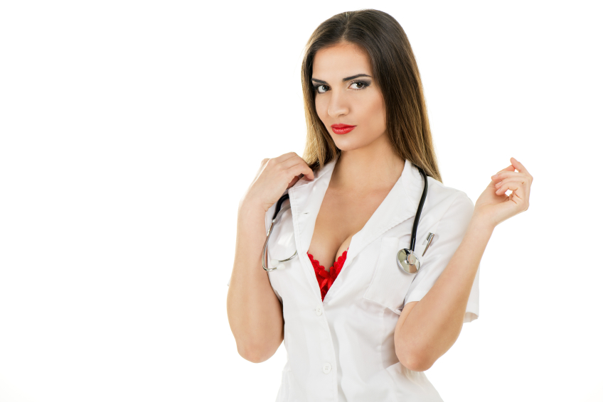 Beautiful smiling sexy nurse standing and posing on white background. Looking at camera.
