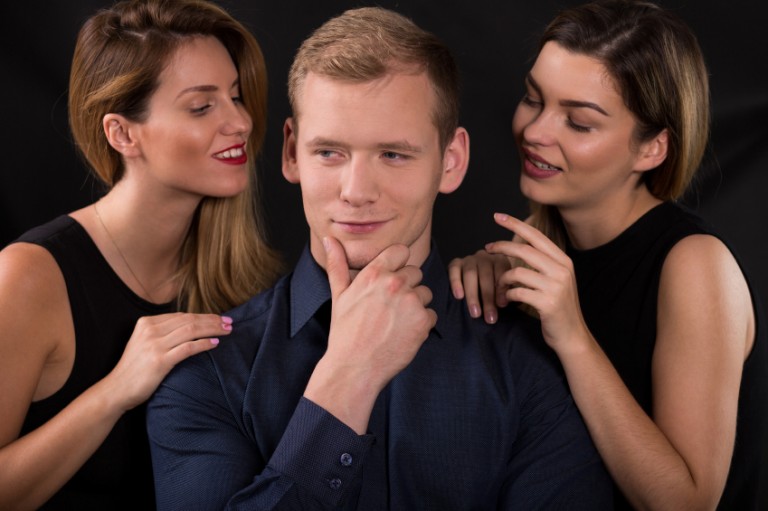 A man contemplating what it would be like to have a threesome with two sexy ladies