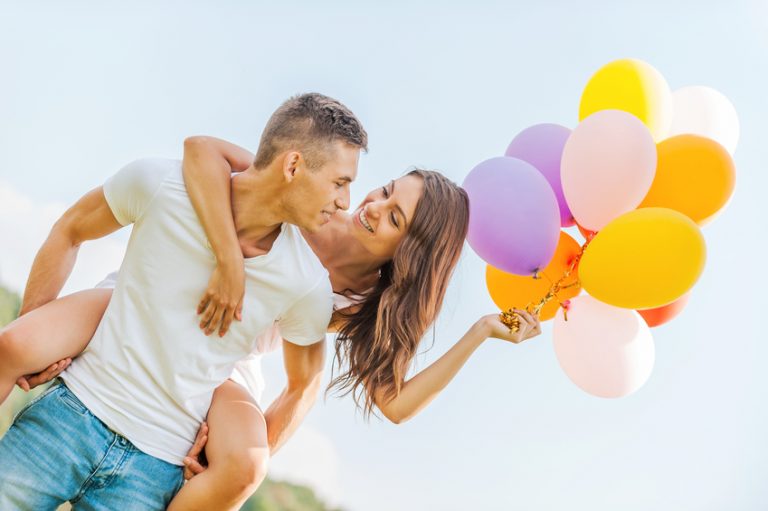 A couple hold balloons to celebrate heterosexual pride day