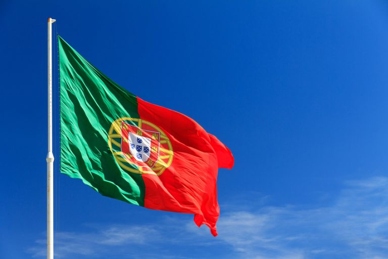 Beautiful large Portuguese flag waving in the wind against a blue background in Lisbon, Portugal