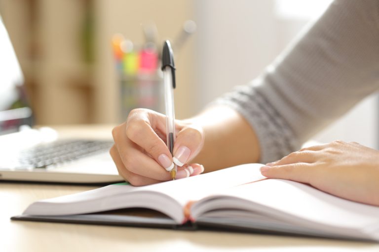 Close up of women writing in her diary