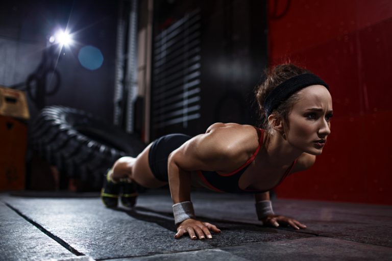 Fit woman doing push-ups in gym