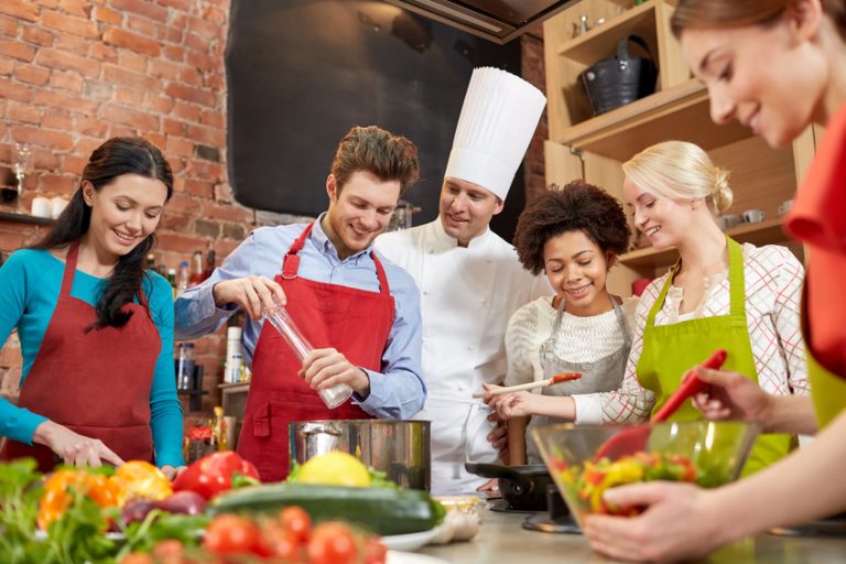 A group gathered in a kitchen, learning to cook