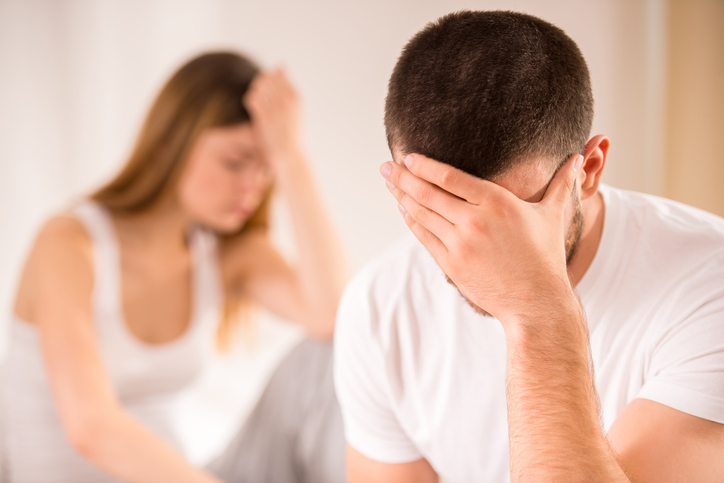 Young couple sad in bed