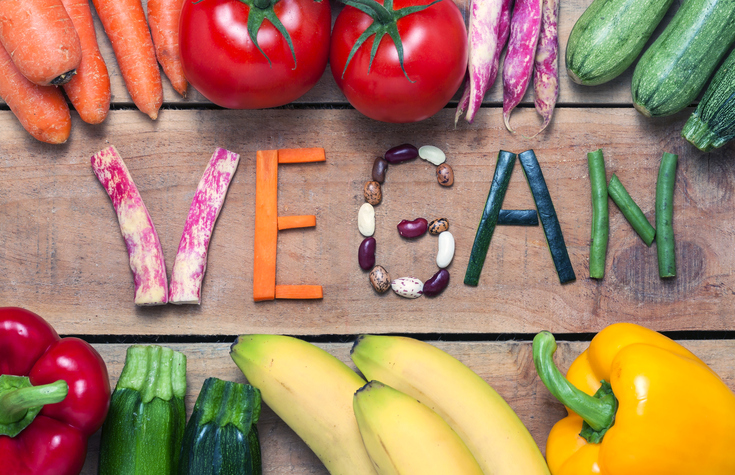 vegan word on wood background and vegetable - food