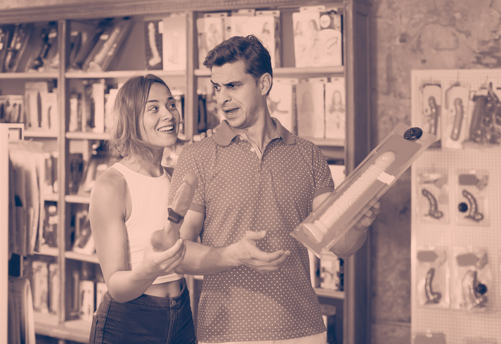 adult french woman and man bayers choosing long rubber phallus in the sex shop