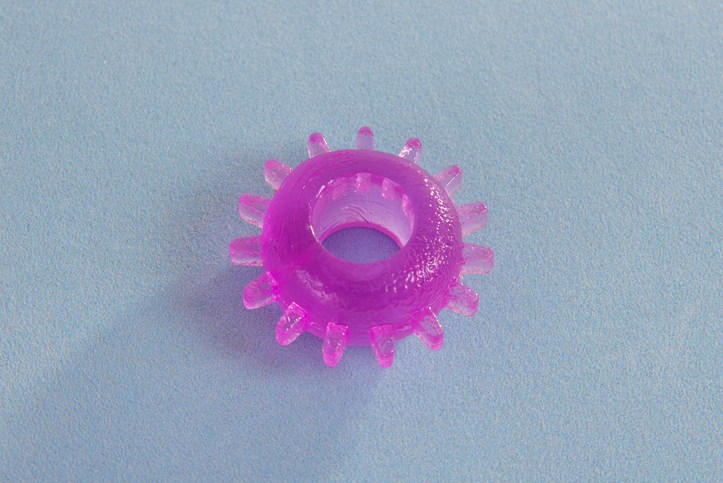 Close up of purple ring holding penis erection