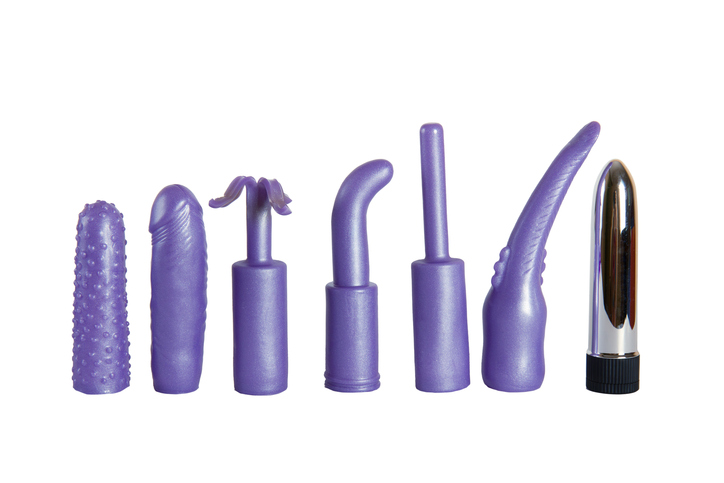 Purple sex toys for woman - vibrator and caps isolated on a white background