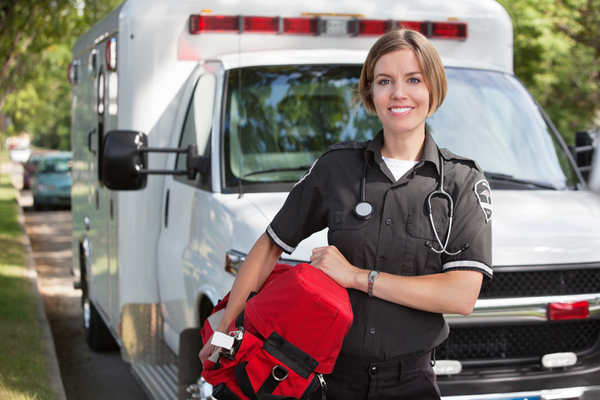 A woman stands in front of an ambulance