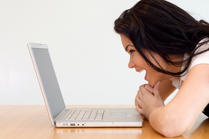 Woman looking at a laptop with shock