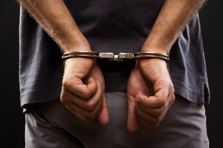 Man with hands in handcuffs behind his back