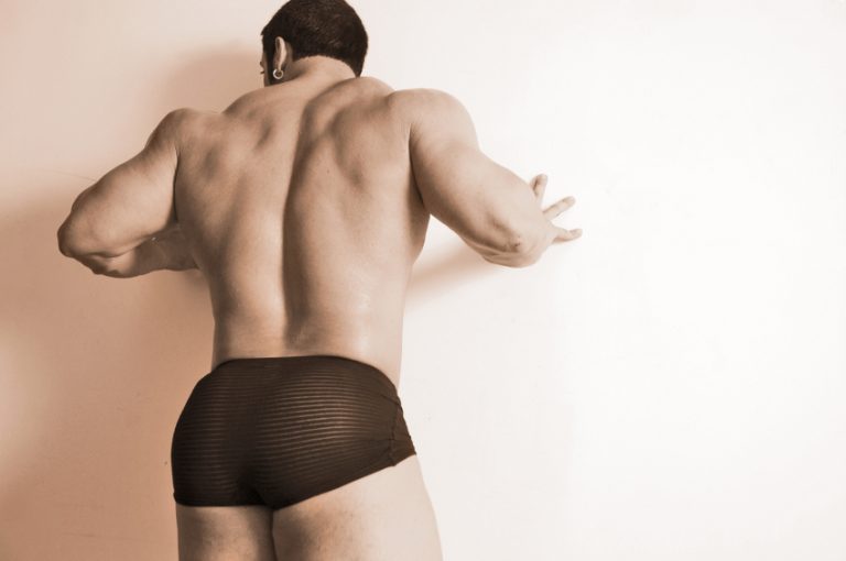 big male model pressing against wall