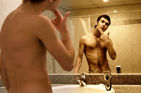 Man shaving in front of mirror