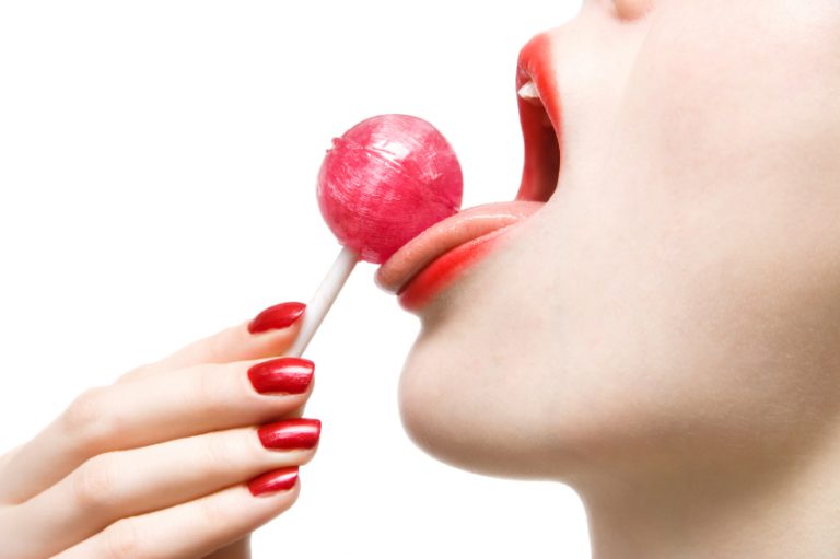 Woman licking a lollipop, testing out some techniques she learned from blowjob porn
