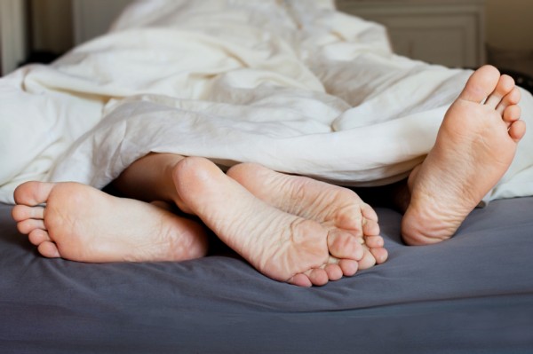 Lovers' feet in the bed