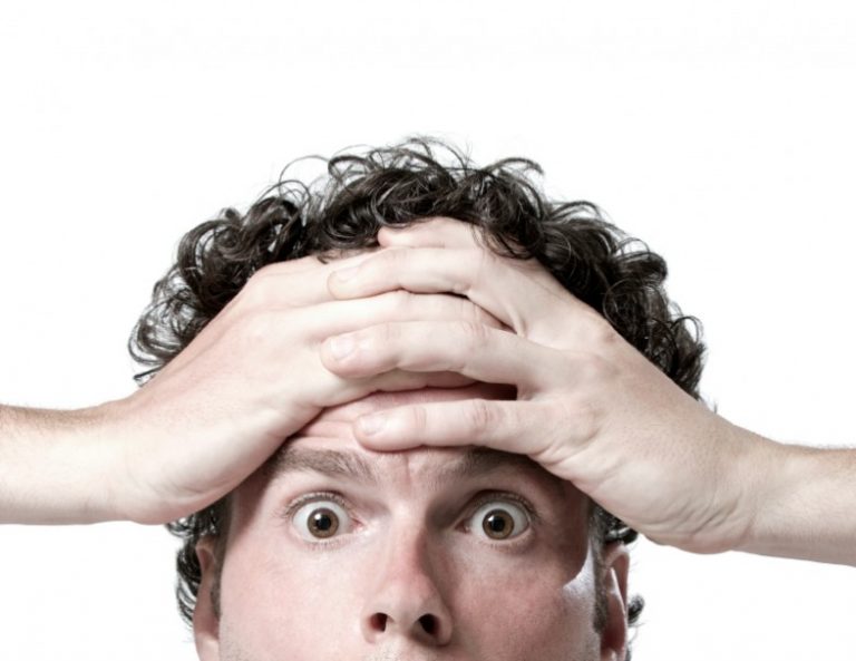 Man holds his forehead looking embarrassed