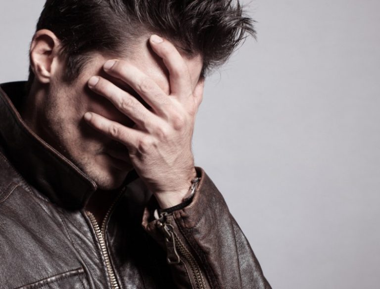 Man putting his hand on his face