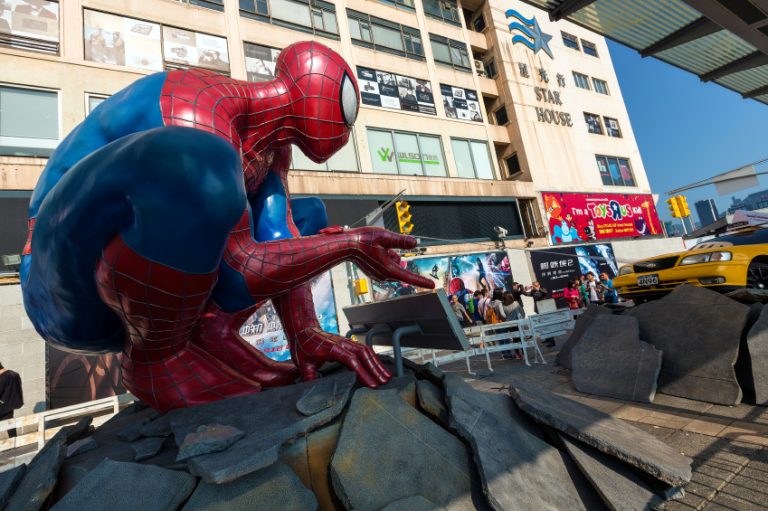 Spidrrman crouches in front of a building